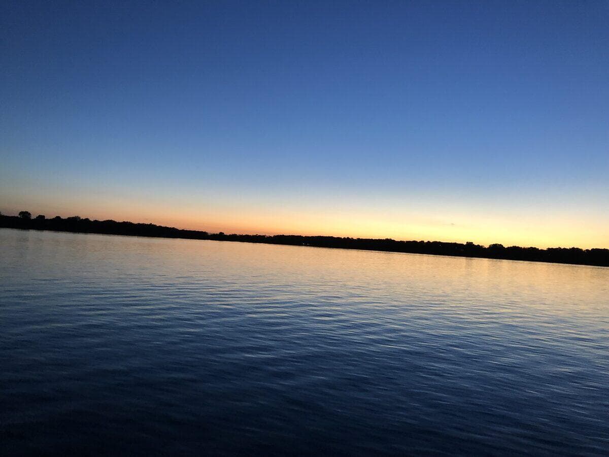 Sunset over a Minnesota lake with fall foliage reflecting in the calm water